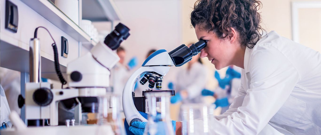 Scientists looking through a microscope